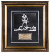 MUHAMMAD ALI signed photograph depicting "The sports photo of the century" - the moment he knocked out Sonny Liston, Round 1, 25th May, 1965. Framed and glazed, with Superstars & Legends Guarantee of Authenticity sticker and certificate. Overall 57 x 54cm