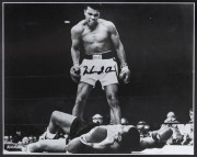 MUHAMMAD ALI signed photograph depicting "The sports photo of the century" - the moment he knocked out Sonny Liston, Round 1, 25th May, 1965. Framed and glazed, with Superstars & Legends Guarantee of Authenticity sticker and certificate. Overall 57 x 54cm - 2