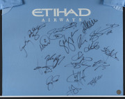 MANCHESTER CITY: mounted display with team jersey signed by members of 2013/14 Premiership & League Cup winning squad, surrounded by action photographs - 2