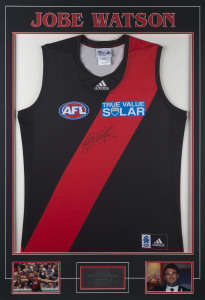 JOBE WATSON (Essendon): Essendon captain's signed guernsey presented on mounted display, two images beneath, one showing Watson with his 2012 Brownlow Medal, plus a metal plaque detailing his career highlights; overall 70x101cm.