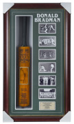 DON BRADMAN: original signature on photograph affixed to a full size replica "Sykes -Don Bradman" cricket bat accompanied by an adjacent array of photographs depicting key moments in "The Don's" career with a commemorative metal plaque beneath, all housed - 2