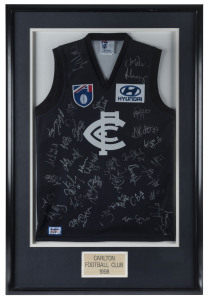 CARLTON: framed and glazed Carlton football guernsey signed by members of 1998 squad, numerous signatures including Stephen Silvagni, Anthony Koutoufides, Brett Ratten, Craig Bradley & Aaron Hamill; overall 71x108cm.