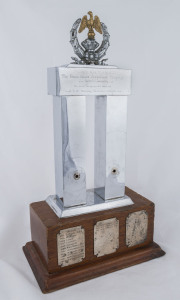 BOXING TROPHY: "The Sir Frank Packer Perpetual Trophy" in polished metal on a heavy wooden plinth, inaugurated in 1954 and awarded to the most successful club in the NSW Boxing Championships with winning club names engraved on plates for the 1954 to 1967 period; some corner damage to base; base 29x16cm, height 51cm, weight 4.7kg.