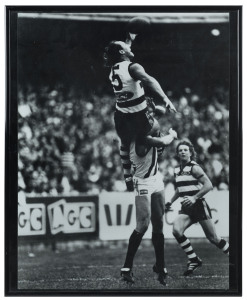 GEELONG - GARY ABLETT SENIOR: framed & glazed photograph of Ablett's 1994 Mark of the Year over Collingwood's Gary Pert at the MCG, overall 41.5x52cm.