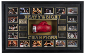 "HEAVYWEIGHT CHAMPIONS" framed display comprising 18 action photographs and six engraved brass plaques surrounding a full-sized boxing glove signed by the six champions: Muhamad Ali, Joe Frazier, George Foreman, Mike Tyson, Lennox Lewis and Evander Holyfi
