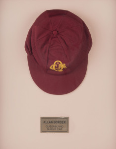 ALLAN BORDER'S QUEENSLAND CRICKET CAP, deep red, embroidered yellow "QCA" monogram on front, "Albion" label inside endorsed "AB" & signed "Allan Border". Fine condition. Attractively framed. [Border represented Queensland in 98 matches between 1980 and 19