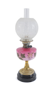 An antique oil lamp with pink hand-painted font and black button double burner, 19th century, ​59cm high