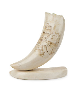 A scrimshaw whale's tooth on stand, 15cm high