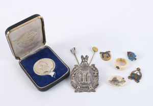 Badges, medal, regimental hat badge, scrimshaw whales tooth section and a whale bone ring, 19th and 20th century. (9 items).