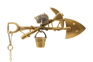A gold miner's brooch, crossed pick and shovel with rope and bucket plus ore specimen, 19th century, stamped "9ct", 4.5cm long, 2.4 grams