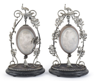 A pair of Australian carved emu eggs decorated with emu, kangaroo and lyre birds, silver plated mounts on ebonised bases, late 19th century, ​33cm high