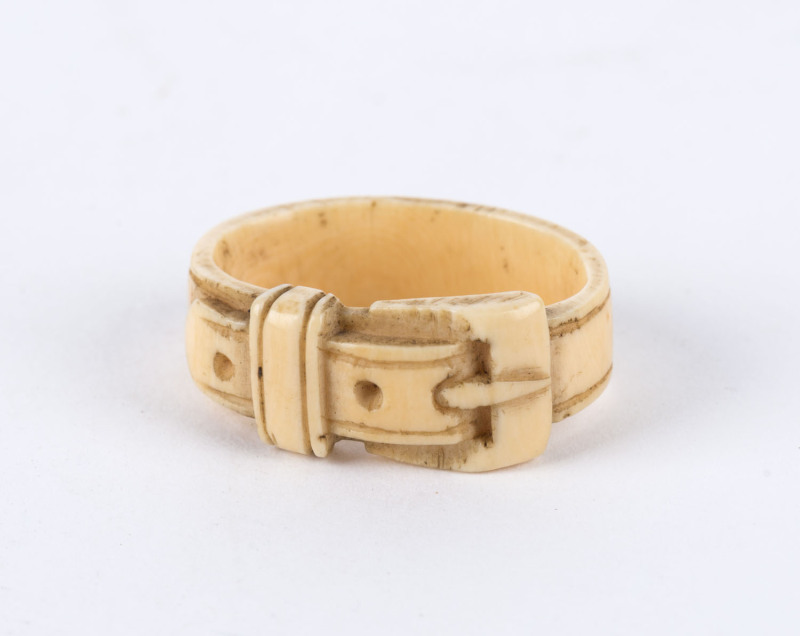 A carved whalebone toggle in the form of a belt and buckle, 19th century, 3cm across