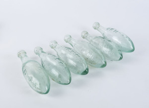 Six torpedo bottles "C.R. MOORE, Daylesford, Established 1862" trade mark with embossed bird logo, 23cm high