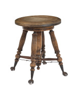 An American revolving piano stool, carved walnut with iron claw feet clutching glass pads, circa 1895, ​45cm high - 2