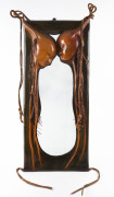 An unusual tribal style mirror with leatherwork frame, late 20th century, ​102 x 45cm