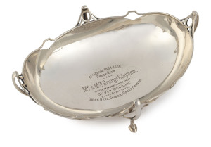 An English Art Nouveau sterling silver bowl with presentation inscription "6th March 1884-1909, To Mr. & Mrs George Clapham On The Celebration Of Their Silver Wedding, By The Staff Of The Union Bank, Grimsby Docks Branch", made in Birmingham, circa 1908, 24cm across the handles, 440 grams