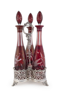 A three bottle silver plated decanter stand with Bohemian ruby overlay glass decanters, circa 1850, 42cm high overall