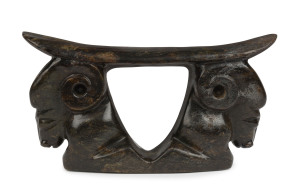 A Chinese headrest pillow, carved nephrite with ram's head decoration, 13.5cm high, 25.5cm across