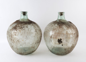 A pair of French wine demijohns, green glass in zinc barrels, early 20th century, 55cm high, 50cm diameter