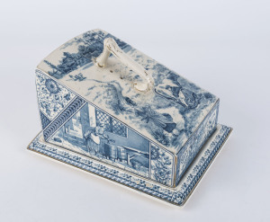 An English porcelain cheese dish and cover, transfer blue and white Aesthetic Movement floral motifs with farm scenes, circa 1875, stamped "Cheshire, Rd. No. 133431", 16cm high, 20cm wide,25cm deep