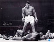 MUHAMMAD ALI, signed b/w photograph of Ali standing over Sonny Liston, size 51x41cm. With 'Online Authentics' No.OA-8090296.