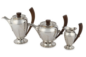 An Art Deco three piece silver plated tea service with wooden handles, possibly Austrian or Danish, circa 1925, pictorial rooster stamp with "12" and "G.D." with inverted trident, the tallest 25.5cm high