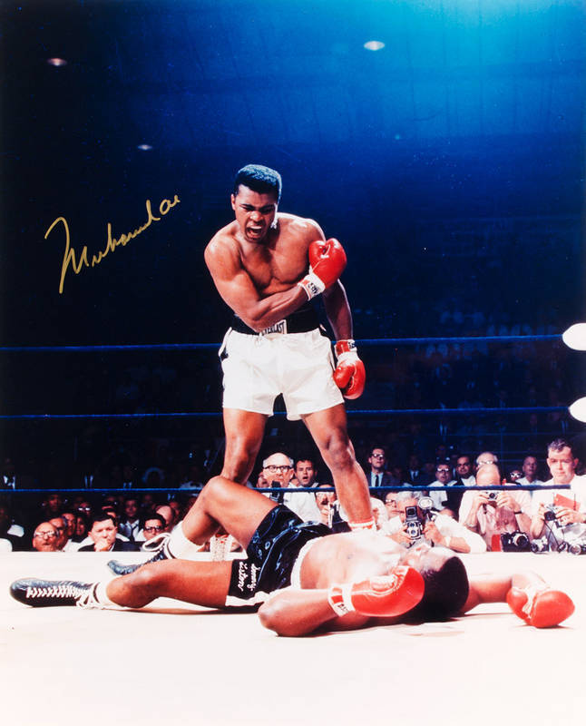 MUHAMMAD ALI, signed colour photograph of Ali standing over Sonny Liston, size 41x51cm. With CoA No.64689.