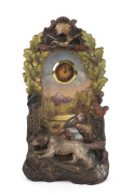 A German ceramic cased clock with black forest scene and hound dog figure, late 19th century, ​40.5cm high