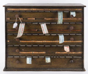 PHARMACIST'S LABEL DISPENSER CABINET: manufactured by McCourt Label Cabinet Co (Bradford, PA, USA), five drawers, some labels remaining, c.1910; 50cm high, 59.5cm wide, 17cm deep.