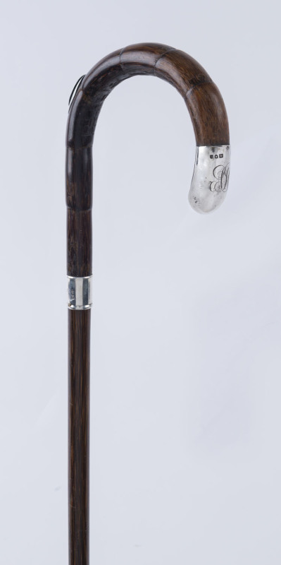 A walking stick, cane shaft with sterling silver collar and cap, also fitted with concealed pencil, ​90cm high