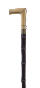 An antique walking stick, stained bamboo shaft, nickel collar and carved whalebone handle, plus concealed fold measuring stick (5 foot), 19th century, 95cm high