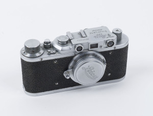 A real Leica II, Model D [#271043; made in 1938] in chrome, with a fake engraved German imperial eagle over M engraving on the view-finder housing. Accompanied by a Leitz Elmar 50mm f3.5 lens,