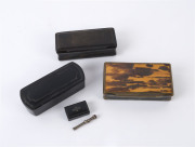 Three snuff boxes, two black papier-m&acirc;ch&eacute; and one horn and tortoiseshell, 18th century, the largest 10cm wide