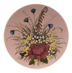 GUY BOYD pottery plaque with Australian wildflowers on pink ground, incised "Guy Boyd, Australia", 23cm diameter