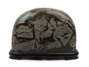 A Chinese scholar's stone, polished agate revealing a windswept landscape, on carved wooden stand, 18cm high, 22cm wide