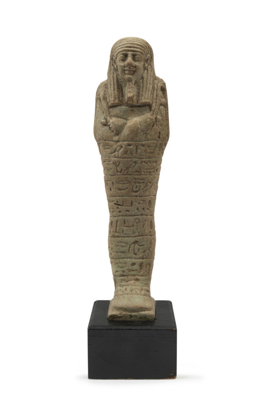 An Egyptian green faience shabti, late period 664-332 B.C. on later wooden base with label "RICHARD H. BLANCHARD, Guaranteed Antiquities, Cairo, Egypt, ", 17cm high