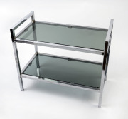 A two tier side table, chrome and smoked glass, circa 1970s, 70cm high, 82cm wide, 43cm deep