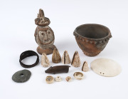 Collection of Papua New Guinea tribal artefacts including, shells, stone disc, arm band, pottery vessels, carved wooden pig and shell pendant, (15 items), the pendant 13cm diameter