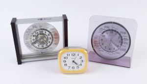 Two world time clocks and a "Meridiana" Italian orange and yellow plastic alarm clock, (3 items), the largest 22cm high