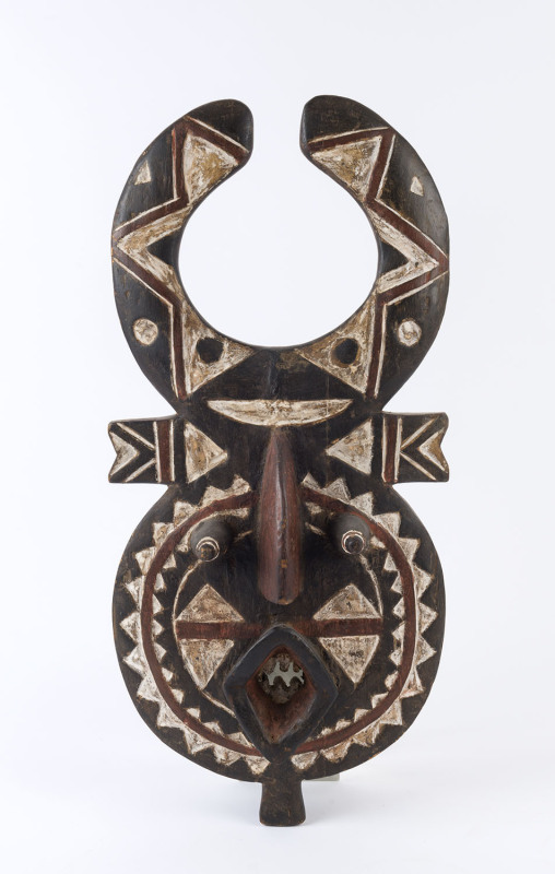 A mask, carved hardwood with remains of ochre and clay decoration, African origin, 67cm high