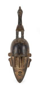 A ceremonial mask with bird totem, carved hardwood, West African origin, 50cm high