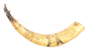 SCRIMSHAW HORN: of large proportions; featuring the bust of a lady with long curly hair, the image of a gentleman with long hair, cravat, pantaloons & sword; aged yellow patina; saw tooth cut into the base & red lined, carved horn stopper; Circa 1860.