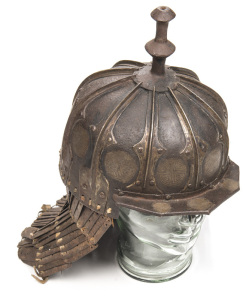 RARE SUMO-TIBETAN SIEGE TYPE IRON HELMET: domed skull formed of 10 overlapping embossed plates to form raised ribs, each plate having a silver inlaid mon type tailman to the bottom edge; the top fitted with a moulded baluster shaped finial; angular peak t