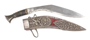 GHURKA KUKRI: g. 12” slender blade of traditional form with areas of v. light staining; brass mounts with horn grip; complete with silver mounted red velvet scabbard decorated with silver embossed Hindu Deities & foliage; woven silver wire keeper with cro