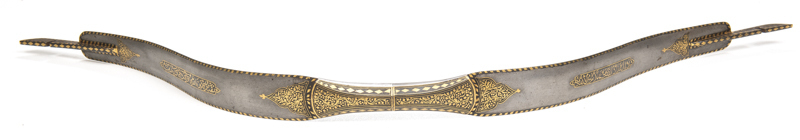 SCARCE INDIAN WATERED STEEL RECURVING HUNTING BOW: gold inlay borders to the full length of the bow to both sides; central hand grip enhanced with floral panels & diamond shaped borders; Indian script to both sides of the hand grips within panels; decorat