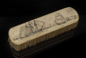 A scrimshaw whalebone brush with naval scene, 19th century, 16.5cm across