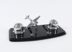 An Art Deco desk set, chrome aeroplane and inkwells on black glass plinth, circa 1930, 35cm across