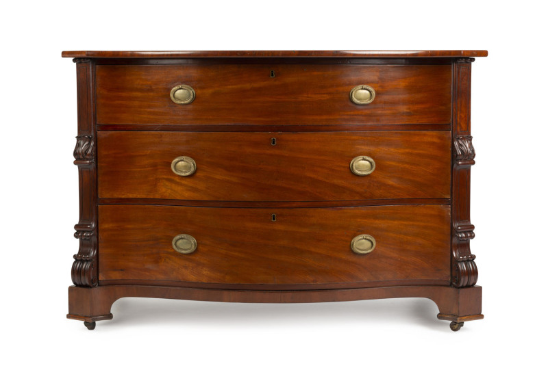 An American three drawer chest with serpentine front, mahogany with ash secondary timbers, circa 1910, 86cm high, 128cm wide, 64cm deep