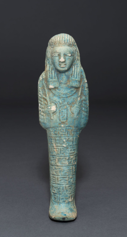 An Egyptian shabti tomb offering, carved stone with green finish, New Kingdom period, circa 1200 B.C. 16.5cm high. PROVENANCE: The Charles Eade Collection