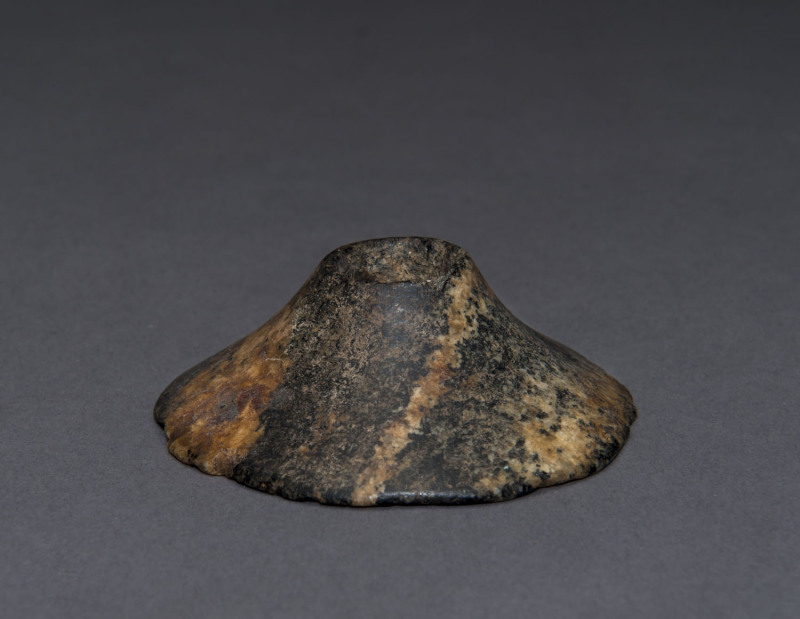 An Egyptian granite stone mace head, predynastic Gerzeh culture, Naqada I, circa 3500 B.C. 2.5cm high, 7.5cm wide. PROVENANCE: The Josef Mueller Collection, Christie's London, November, 1979.